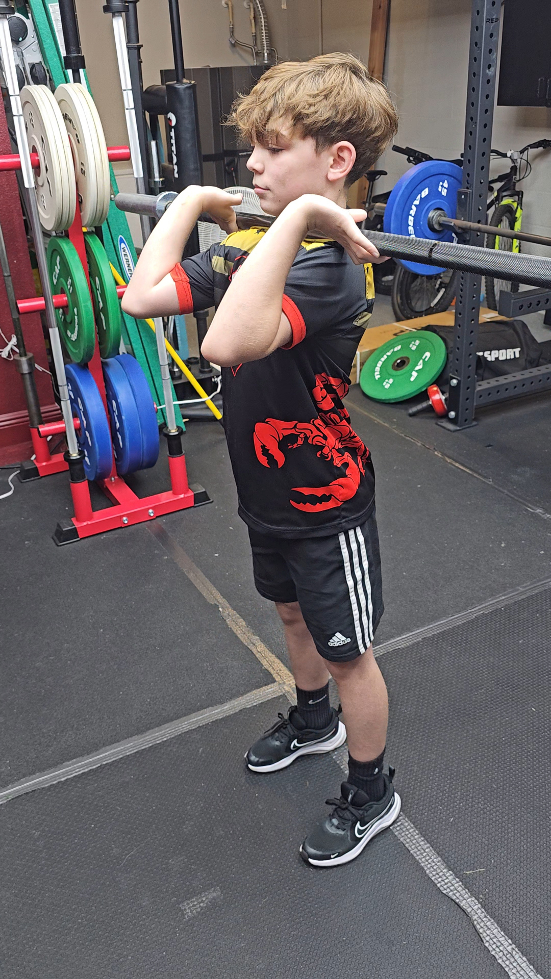 Youth athlete front squatting during a coached strength session