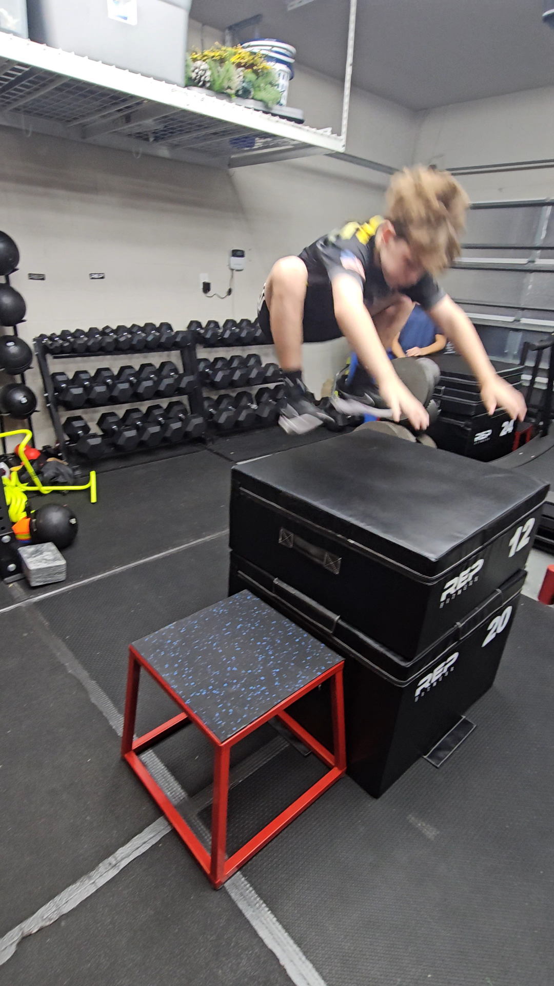 Youth athlete performing a box jump during a conditioning block